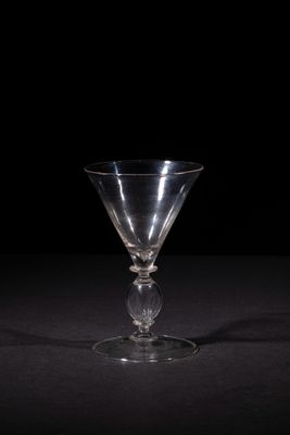an empty wine glass sitting on top of a black table