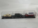 three toy cars are in a display case on a white surface