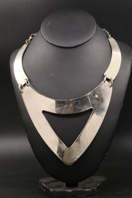 un gros plan d'un collier en argent sur un mannequin
