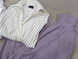 purple pants and a white shirt sitting on a couch next to a pillow
