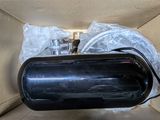 a black speaker in a cardboard box with a plastic bag