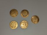 quatre types différents de pièces d'or sur une surface blanche