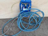 a blue hose attached to a wall next to a blue hose