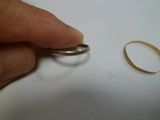 une personne tenant une bague en argent ornée d'un anneau en or