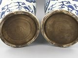 pair of blue and white vases sitting on top of a table