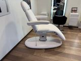 une chaise blanche qui se trouve dans une pièce avec un parquet