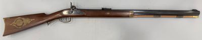 un vieux fusil accroché au mur à côté d'une clé