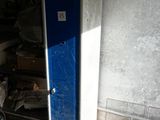 a bike that is parked in front of a blue refrigerator