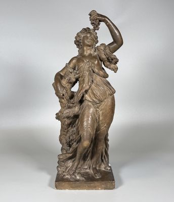une statue en bronze représentant une femme avec un oiseau sur l'épaule