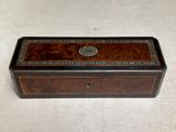 a small wooden box with a decorative design on the lid