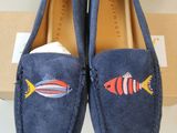 a pair of blue loafers with fish embroidered on them
