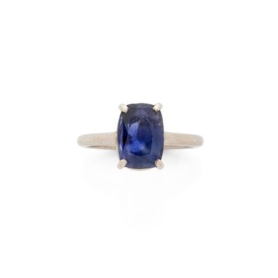 une bague en saphir bleu avec un anneau en or sur fond blanc