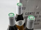 three bottles of wine sitting on top of a table next to a box