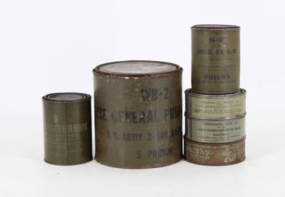 several old tins of different sizes and colors are stacked on top of each other