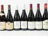 six bouteilles de vin sont alignées sur une table