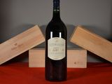 a bottle of wine sitting on a table next to two wooden boxes