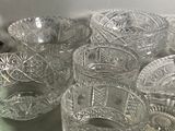 a lot of glass bowls and cups sitting on a table