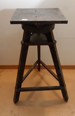 une petite table avec un plateau noir posée sur un piètement en bois