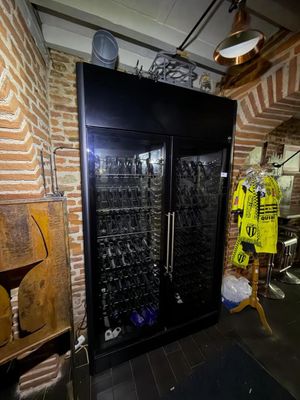 a wine cooler in a room with a lot of bottles