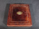 an old wooden box with a gold medallion on it
