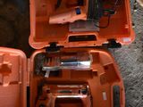 deux outils orange dans un coffret posé par terre