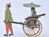a figurine of a man and a woman pulling a cart