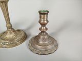 two silver candlesticks sitting next to each other on a table