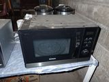 two microwaves sitting on a table next to each other