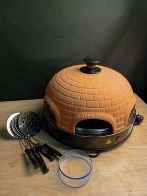 un four à pizza posé sur une table en bois