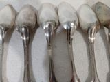 six cuillères sont alignées sur une table