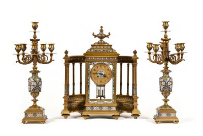 a gold clock and three candelabs on a white background