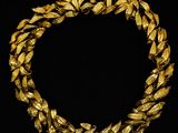 un collier en or orné de feuilles sur fond noir