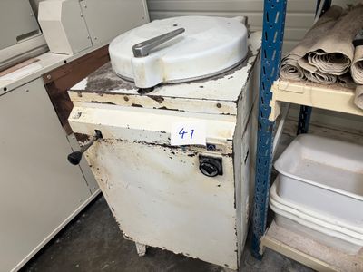 un poêle blanc posé à côté d'une pile de vaisselle blanche