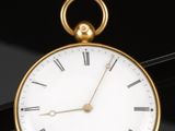 a gold pocket watch with roman numerals on it