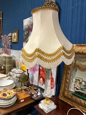 une table sur laquelle se trouvent une lampe et des assiettes, dans une pièce
