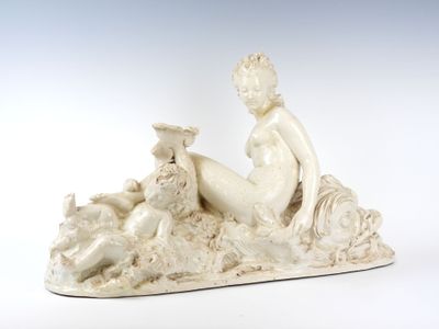une statue représentant une femme assise sur un rocher, à côté d'un chien