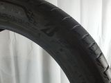 a close up of a tire on a white surface with a curtain in the background