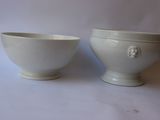 two white bowls sitting next to each other on a table