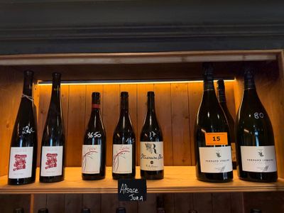Des bouteilles de vin sont alignées sur une étagère dans un magasin de vins.