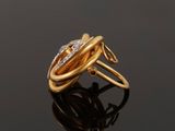 an image of a gold and diamond ring on a black surface