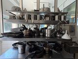 many pots and pans sitting on a shelf in the kitchen