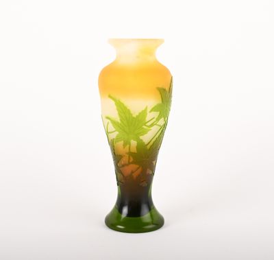 un vase en verre orné d'une plante, posé sur une surface blanche
