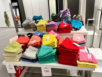 beaucoup de chemises colorées posées sur une table dans un magasin
