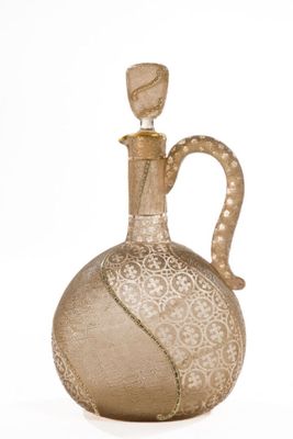a glass bottle with a gold decoration on it