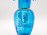 a blue glass vase with a flower in it
