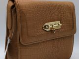 the brown purse is sitting on a white surface