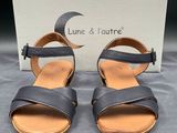 une paire de sandales en cuir noir à deux lanières et à bout ouvert