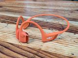 an orange headphones sitting on top of a wooden table
