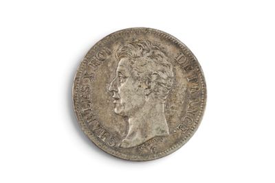 une vieille pièce de monnaie avec un visage d'homme sur une surface blanche