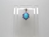 boucles d'oreilles en forme de fleurs turquoise et violettes, présentées dans un présentoir en acrylique transparent